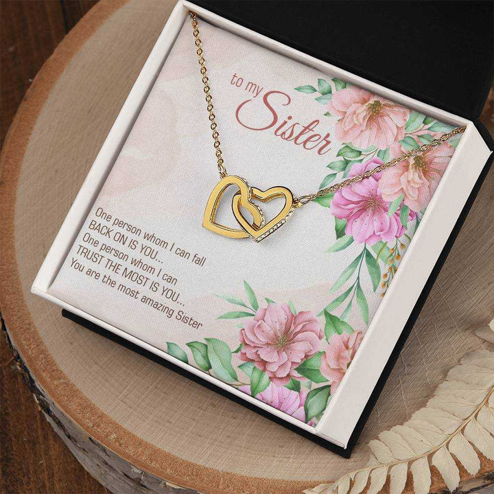 Interlocking Hearts Necklace for Sister with cubic zirconia crystals and rose gold finish displayed on a soft background
