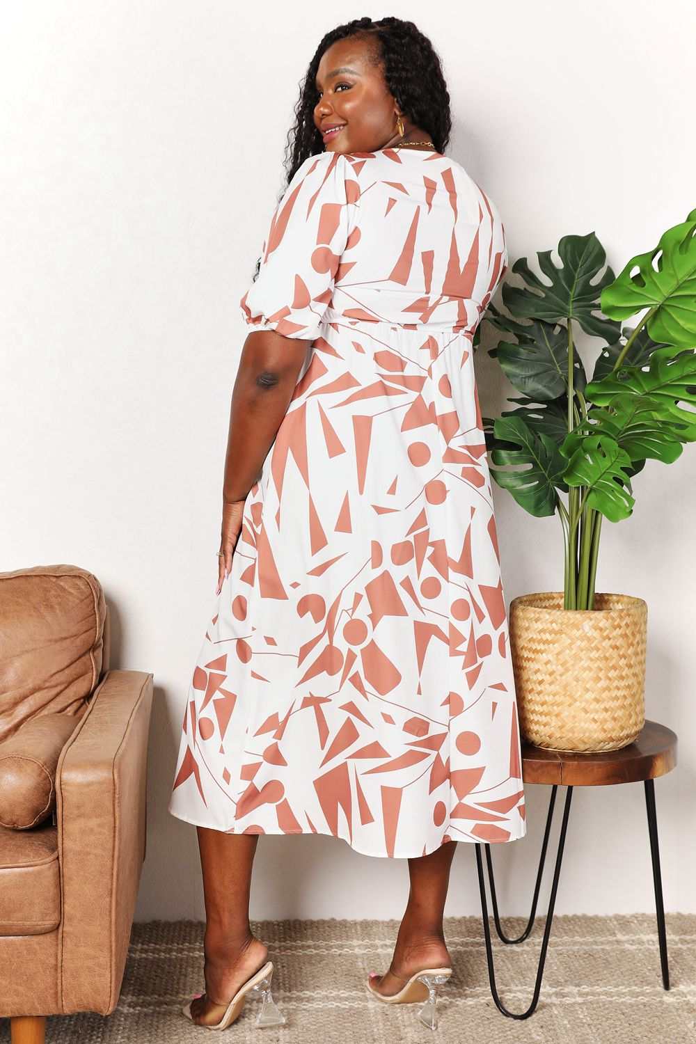 Plus-size model wearing Printed Surplice Balloon Sleeve Dress with geometric pattern, showcasing elegant style and flattering fit.
