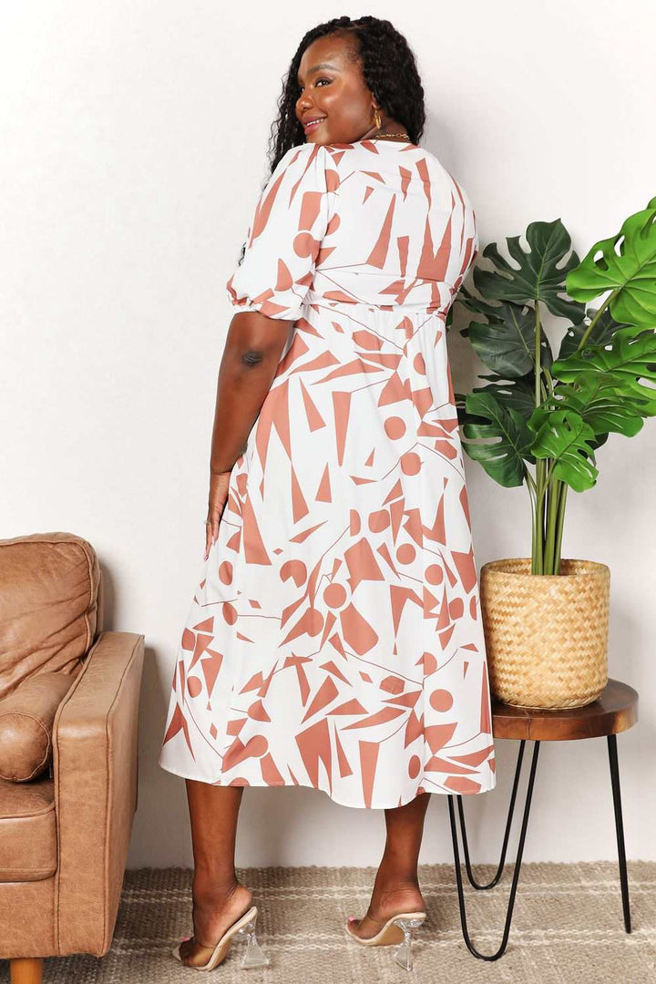 Plus-size model wearing Printed Surplice Balloon Sleeve Dress with geometric pattern, showcasing elegant style and flattering fit.