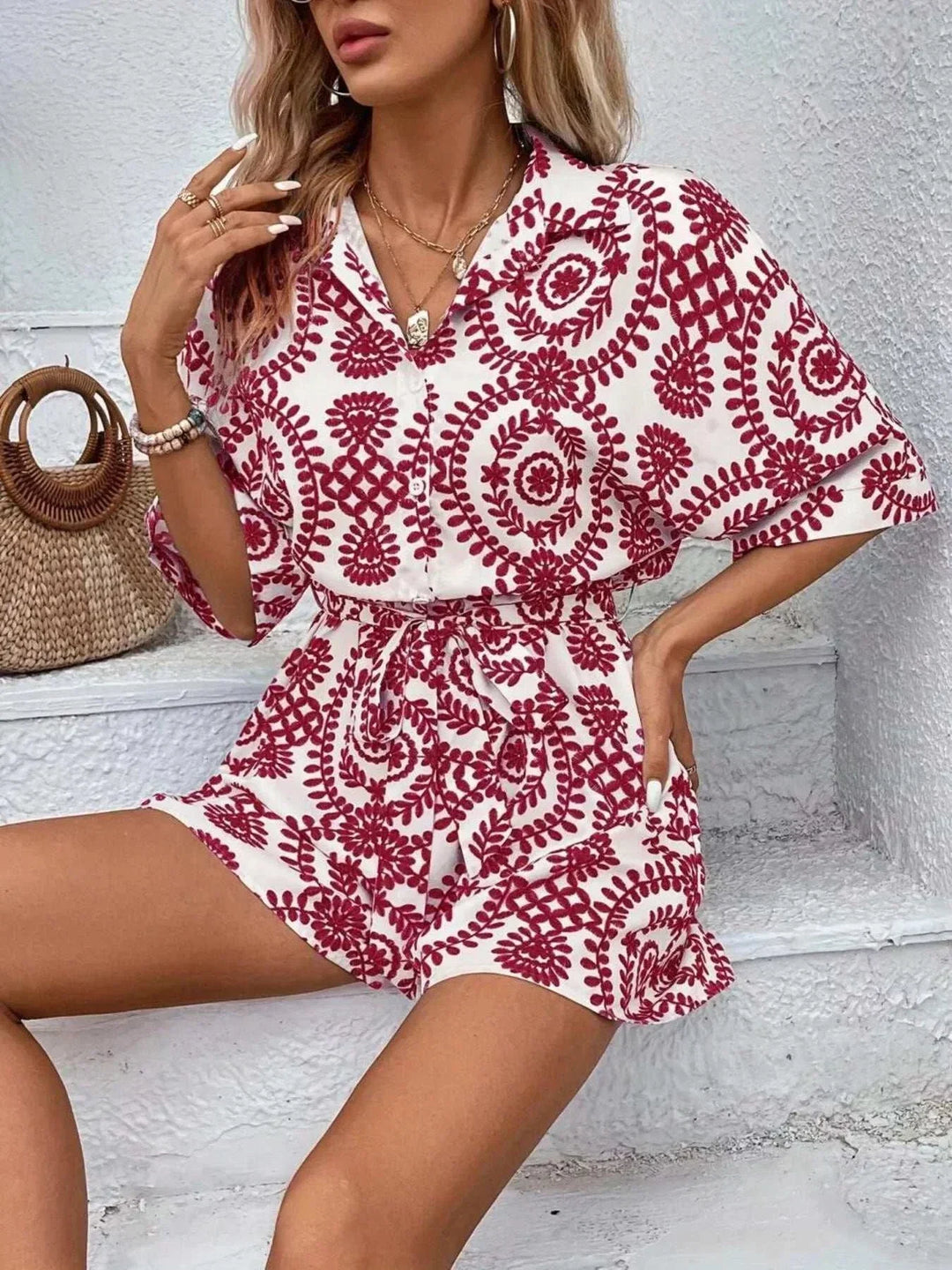 Woman wearing a stylish printed tie waist button-front romper from Hot Topic Goods