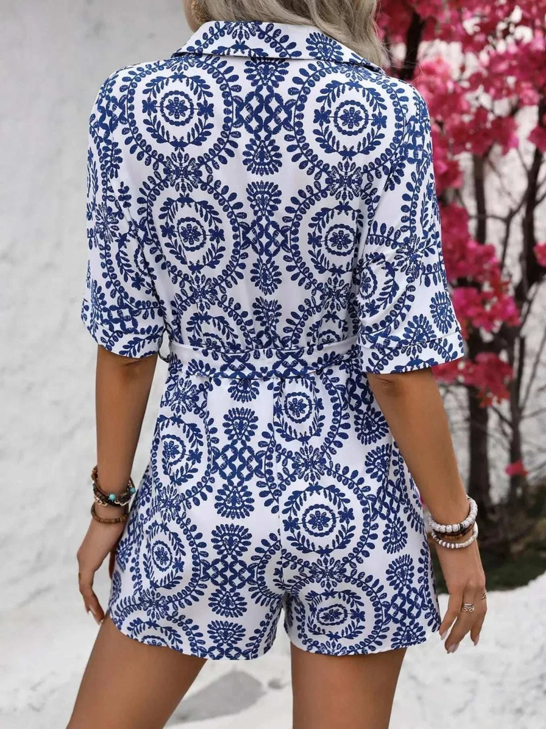 Woman wearing a printed tie waist button-front romper from Hot Topic Goods on a casual outdoor outing