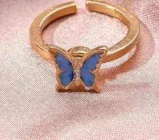 Fidget Spinner Ring with blue butterfly design on a pink fabric background.