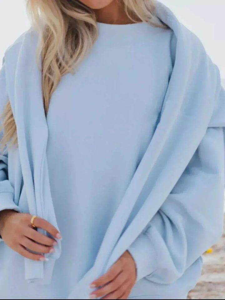 Woman wearing relaxed sweatshirt and matching shorts set from Hot Topic Goods in casual pose