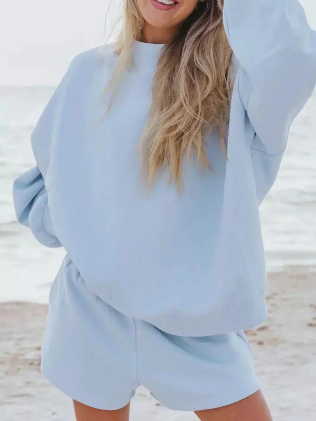 Woman wearing relaxed sweatshirt and matching shorts set from Hot Topic Goods in casual pose