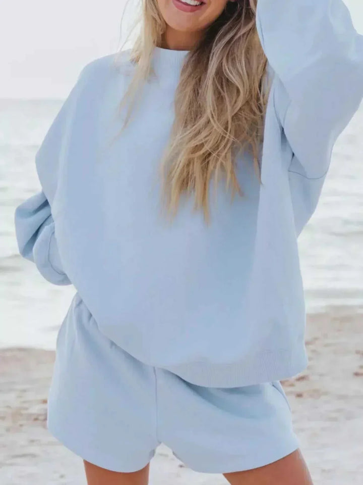 Woman wearing relaxed sweatshirt and matching shorts set from Hot Topic Goods in casual pose