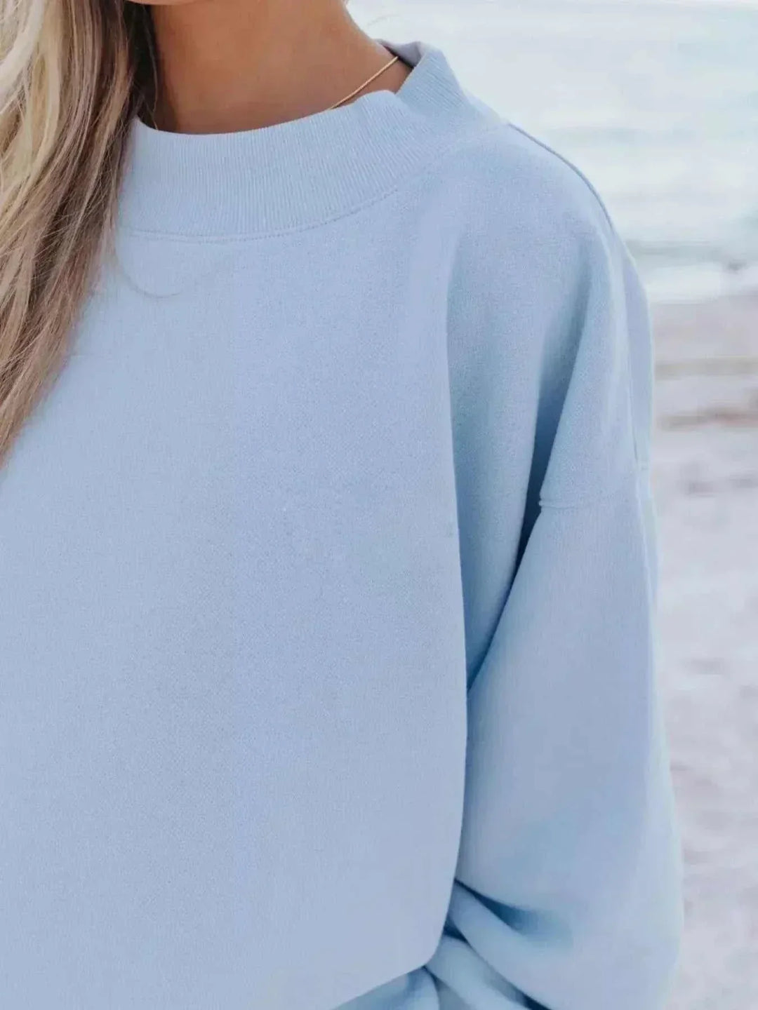 Woman wearing relaxed sweatshirt and matching shorts set from Hot Topic Goods in casual pose