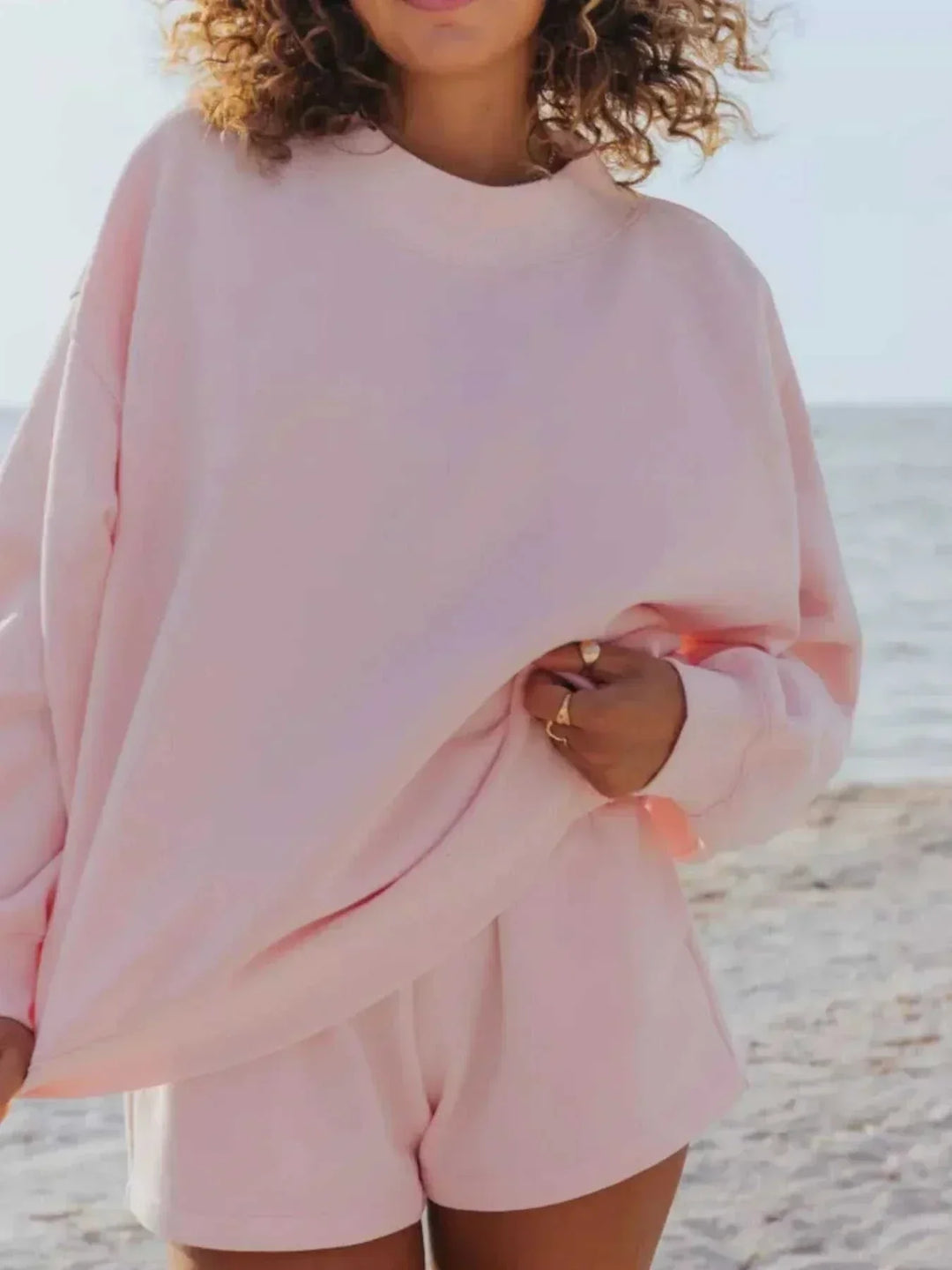 Woman wearing relaxed sweatshirt and shorts set from Hot Topic Goods in casual comfortable style
