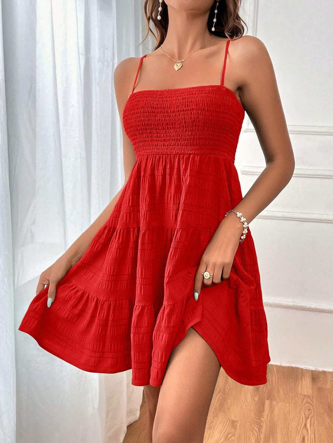 Woman wearing a square neck pleated beach sundress in a flowing silhouette from Hot Topic Goods