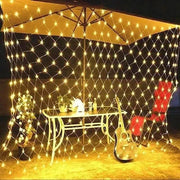Net Mesh Solar Fairy Lights illuminating an outdoor garden setup.