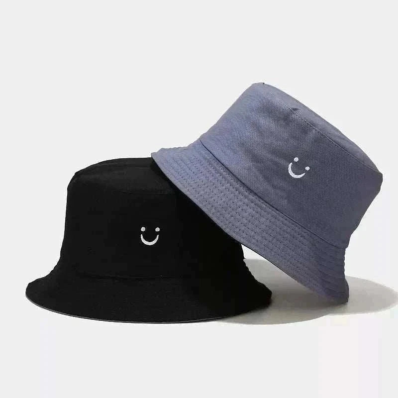 Women’s Smiley Face Bucket Hat in black and slate blue fabric, each with a small white embroidered smiley face