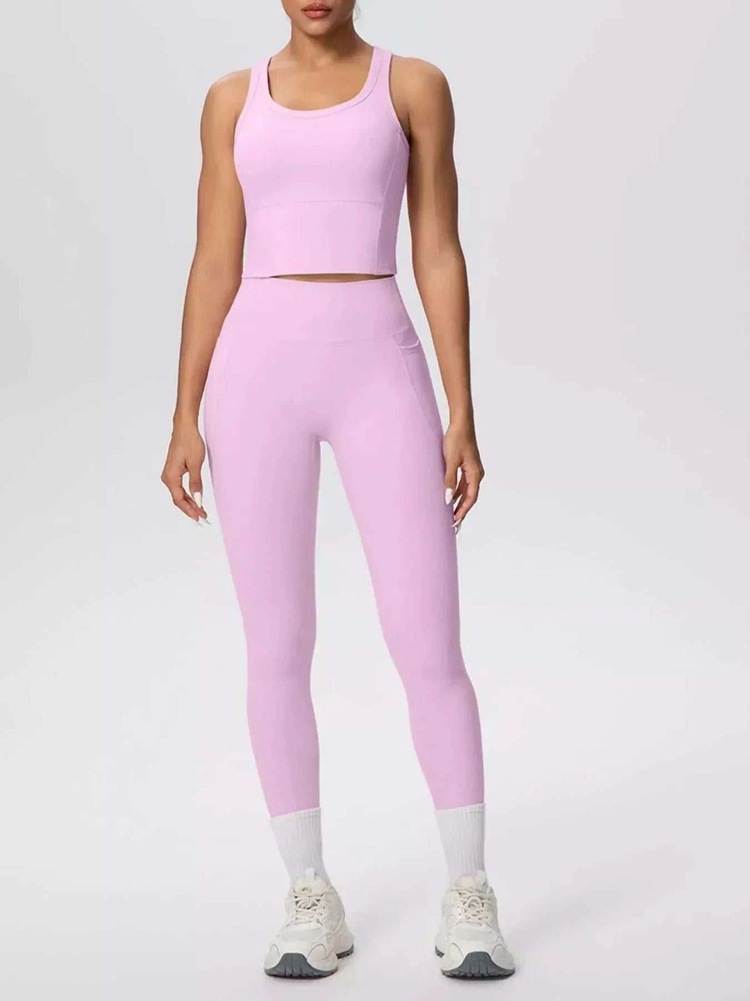 Women’s Tank and Leggings Set in solid pastel pink stretch fabric, with a scoop-neck cropped tank and high-waisted leggings.