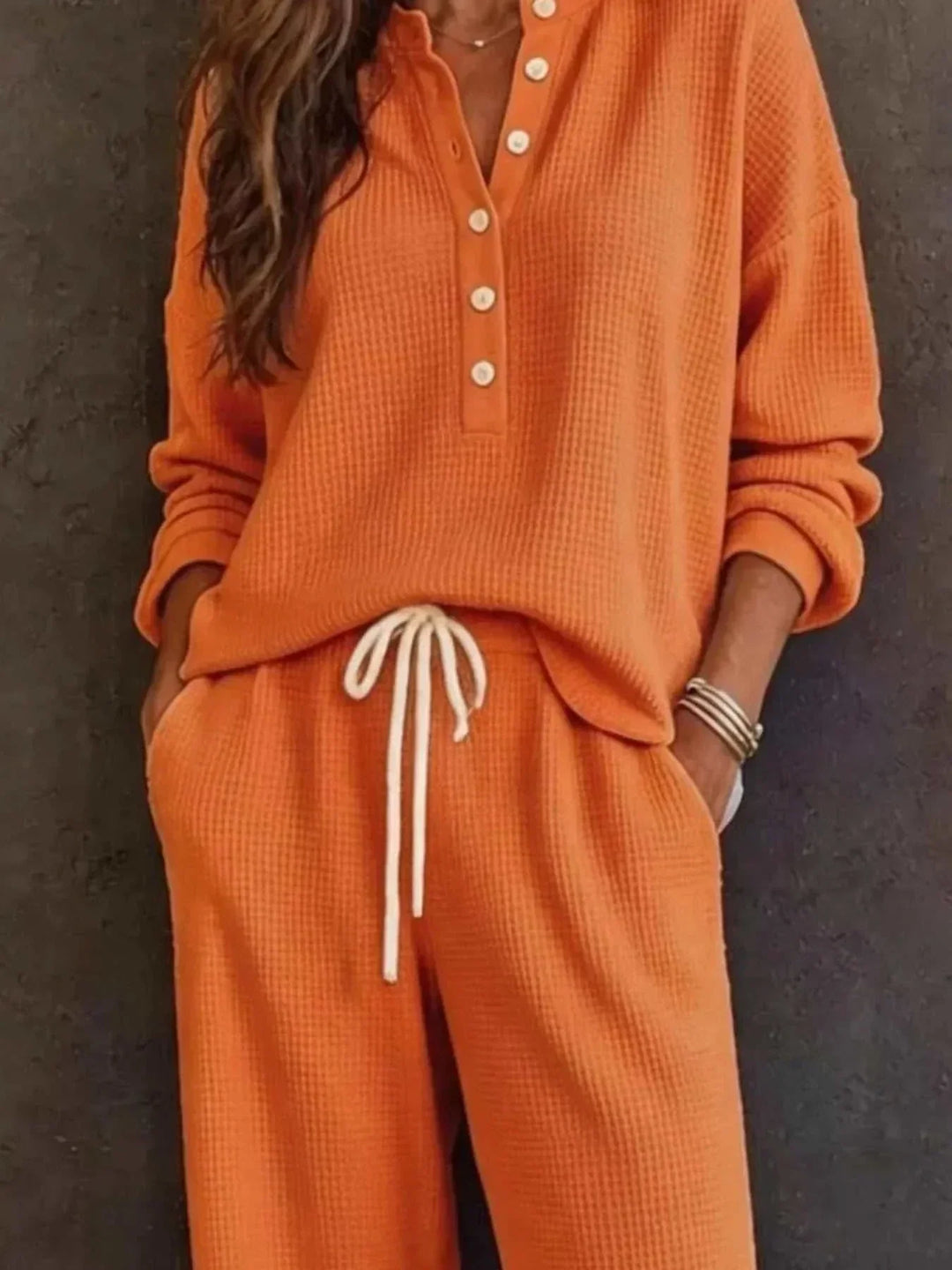 Women’s Waffle Knit Set in orange waffle-textured fabric, with a long-sleeve button-front top and drawstring pants.