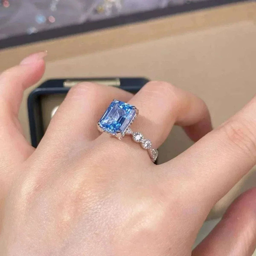 Women’s Zircon Statement Ring in silver-tone metal with a large rectangular blue gemstone and small clear accents