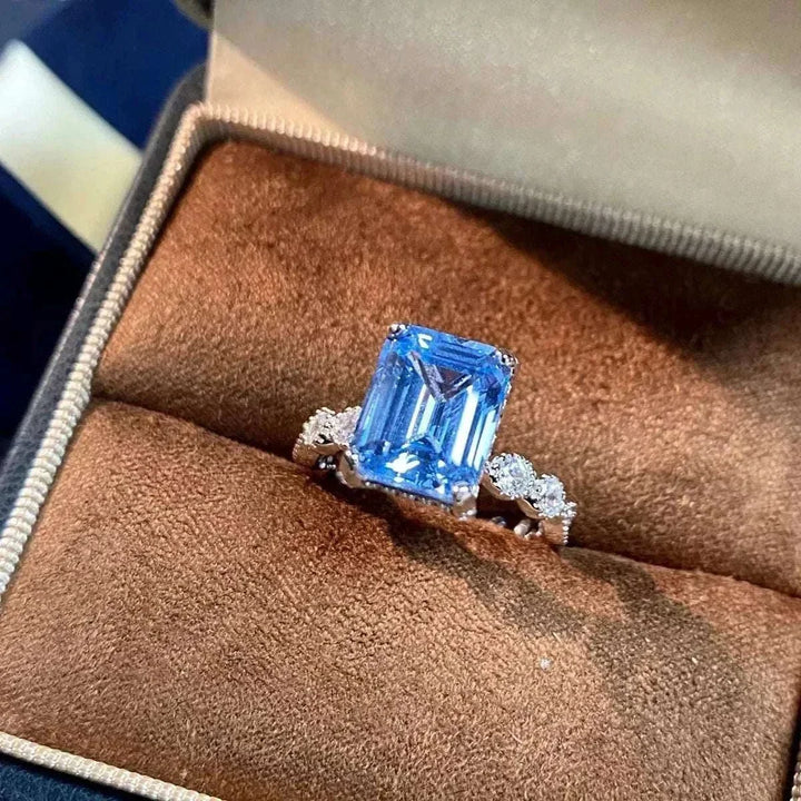 Women’s Zircon Statement Ring with a large rectangular blue gemstone and small clear side stones in a silver-tone setting