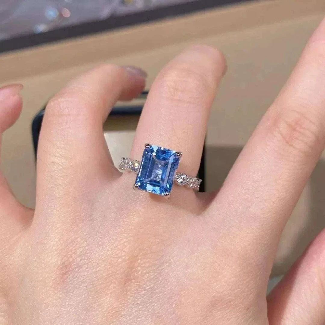 Women’s Zircon Statement Ring with a rectangular blue center stone, clear accent stones and a silver-tone band