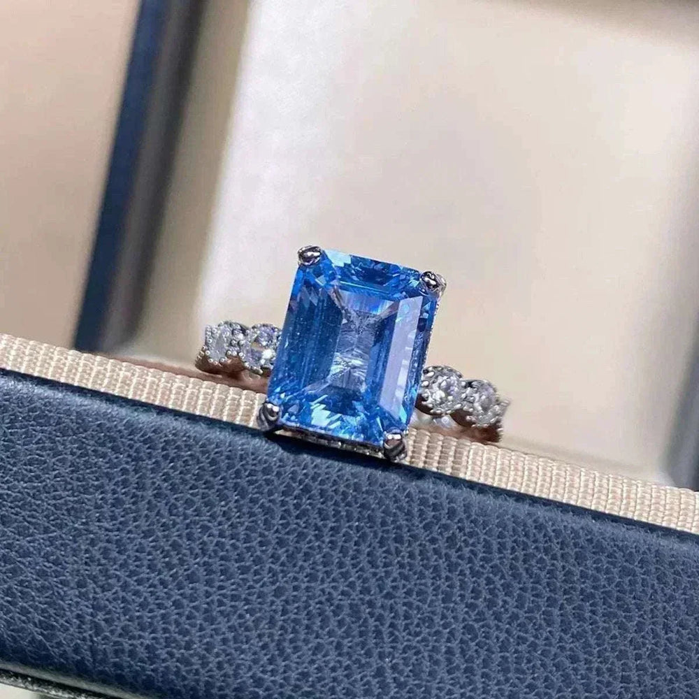 Women’s Zircon Statement Ring in silver tone with a large rectangular blue stone and small clear side stones