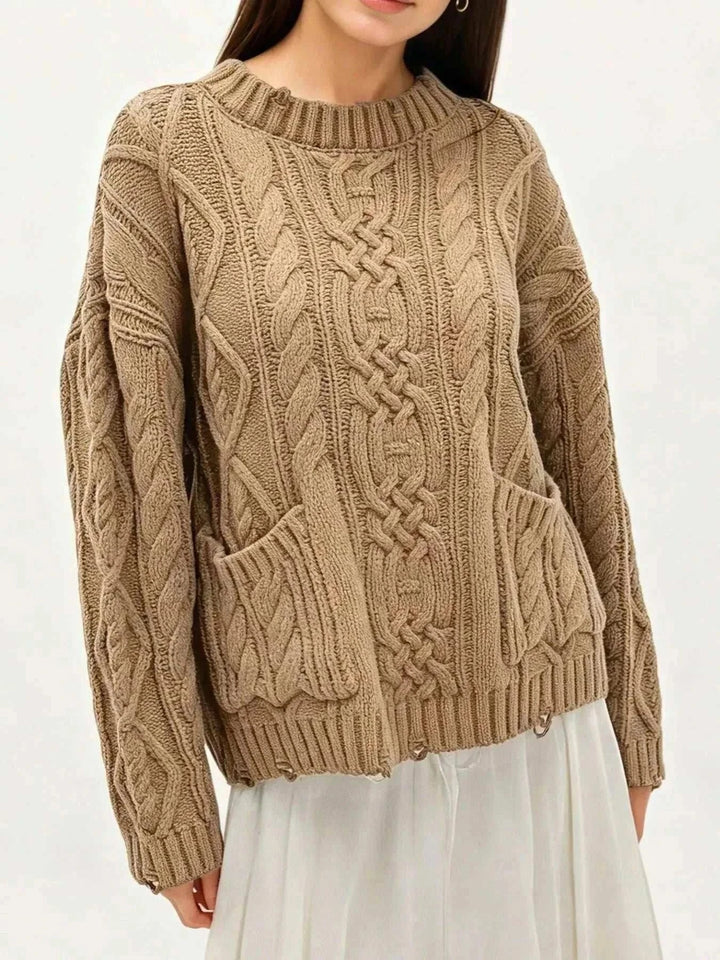 Women’s cable-knit pocket sweater in cream color with long sleeves and cozy textured knit design