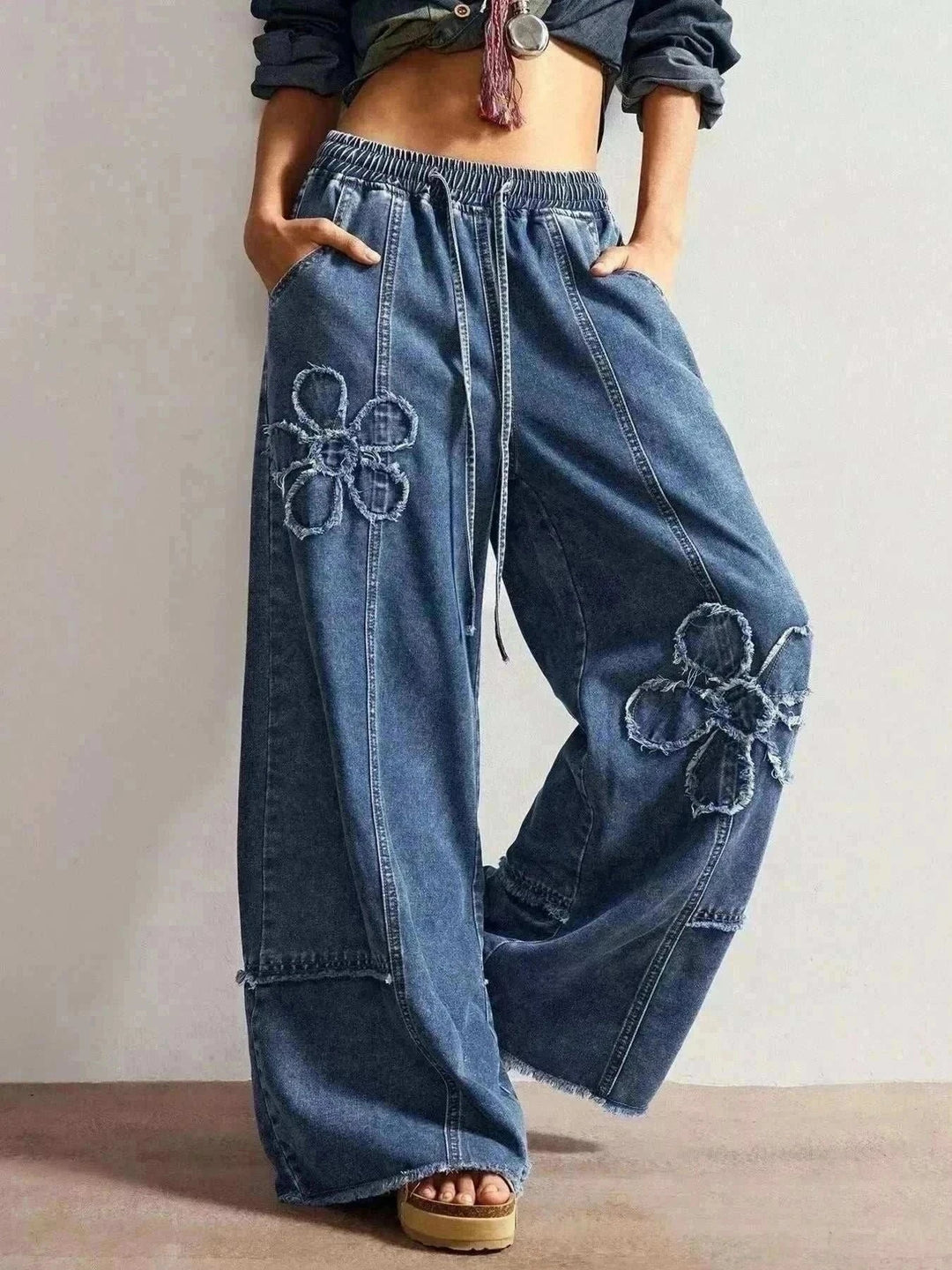 Women's Floral Wide Leg Jeans in blue denim with an elastic drawstring waist and large outlined flower appliqués