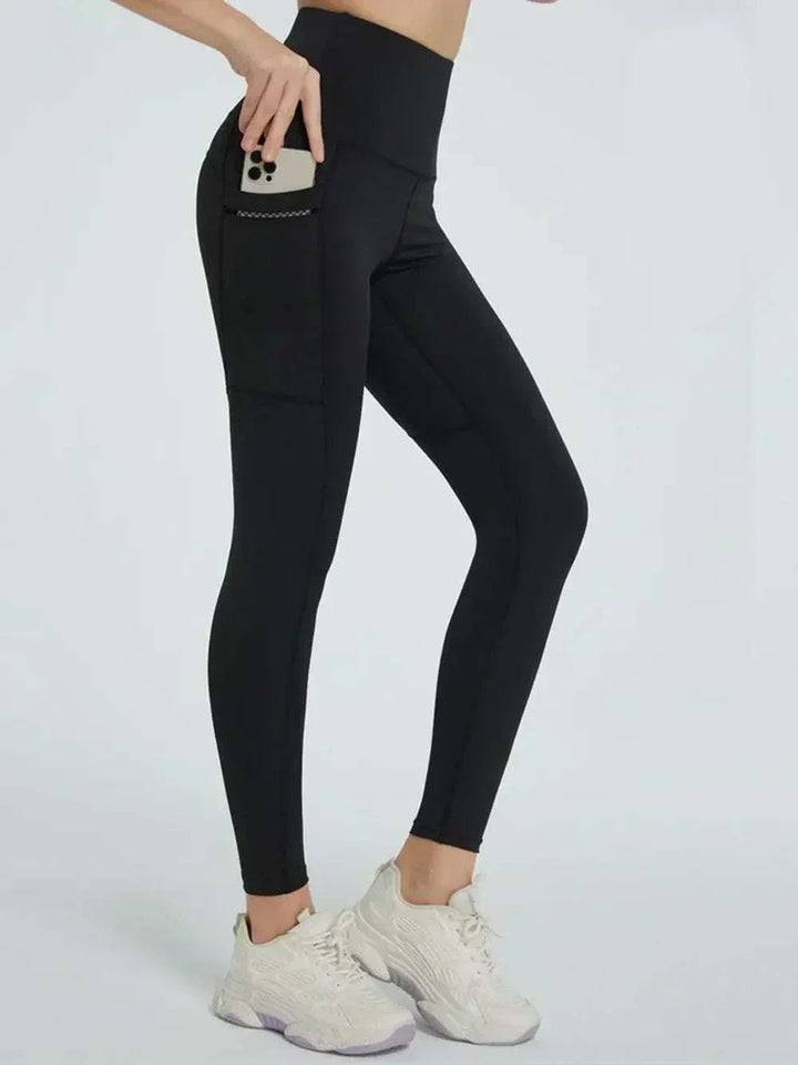 Women’s High-Waisted Leggings in dark green stretch fabric, featuring a wide waistband and small side pocket