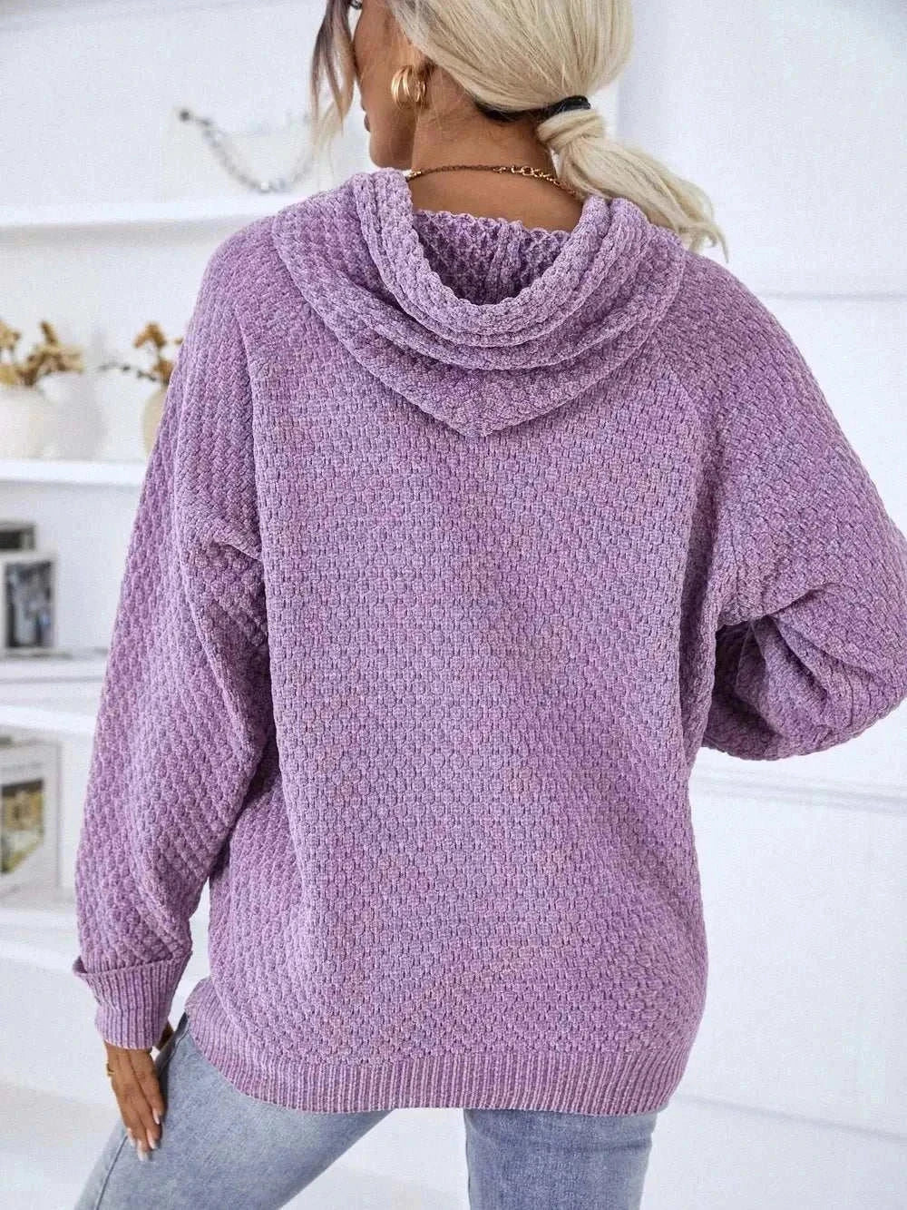 Woman wearing a Women's Hooded Drawstring Sweater with Textured Knit from Hot Topic Goods in casual fall outfit