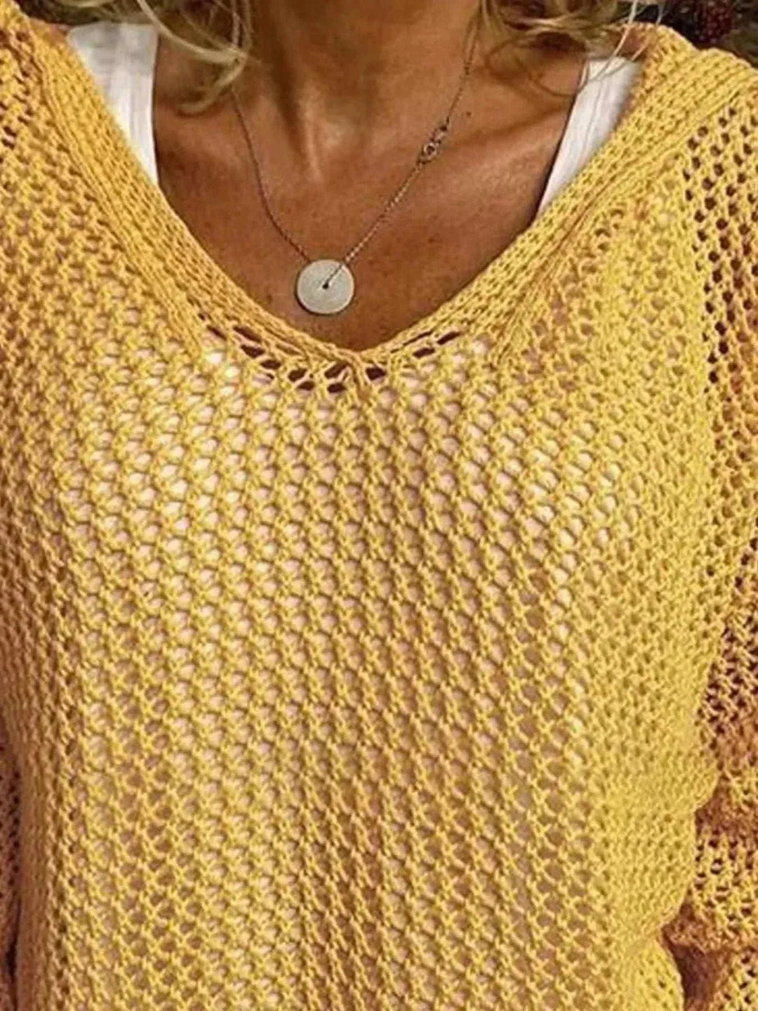Woman wearing a lightweight women’s hooded knit cover-up with long sleeves and openwork design at the beach