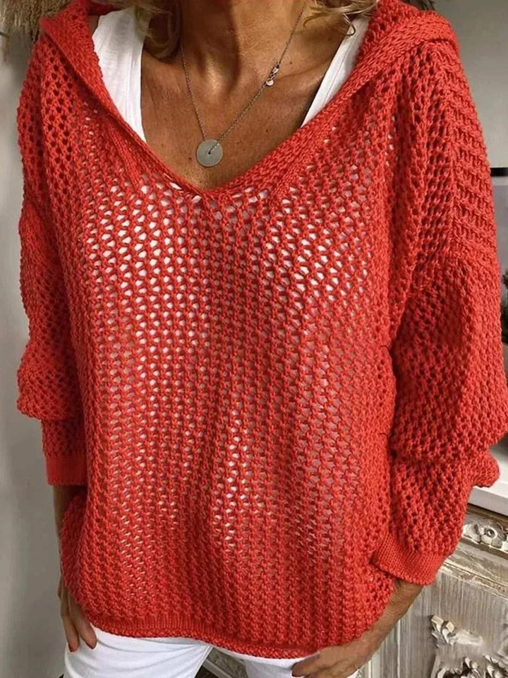 Woman wearing a lightweight openwork knit hooded cover-up from Hot Topic Goods over swimwear at the beach