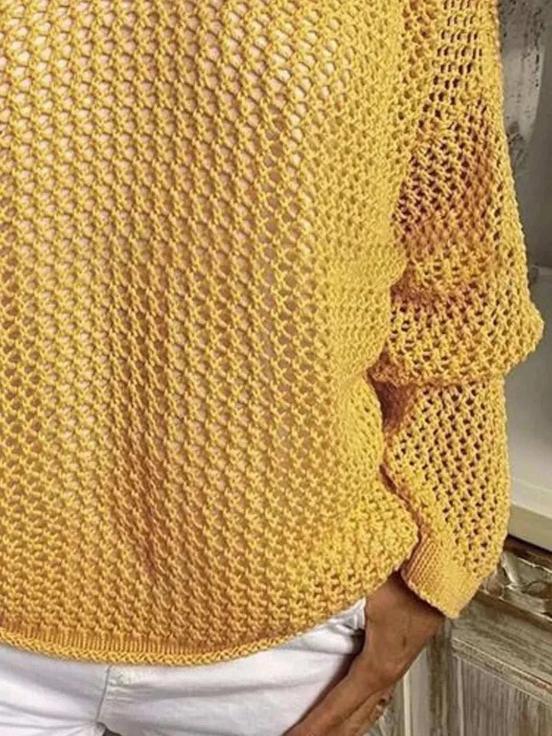 Woman wearing a lightweight openwork knit hooded cover-up by Hot Topic Goods at the beach