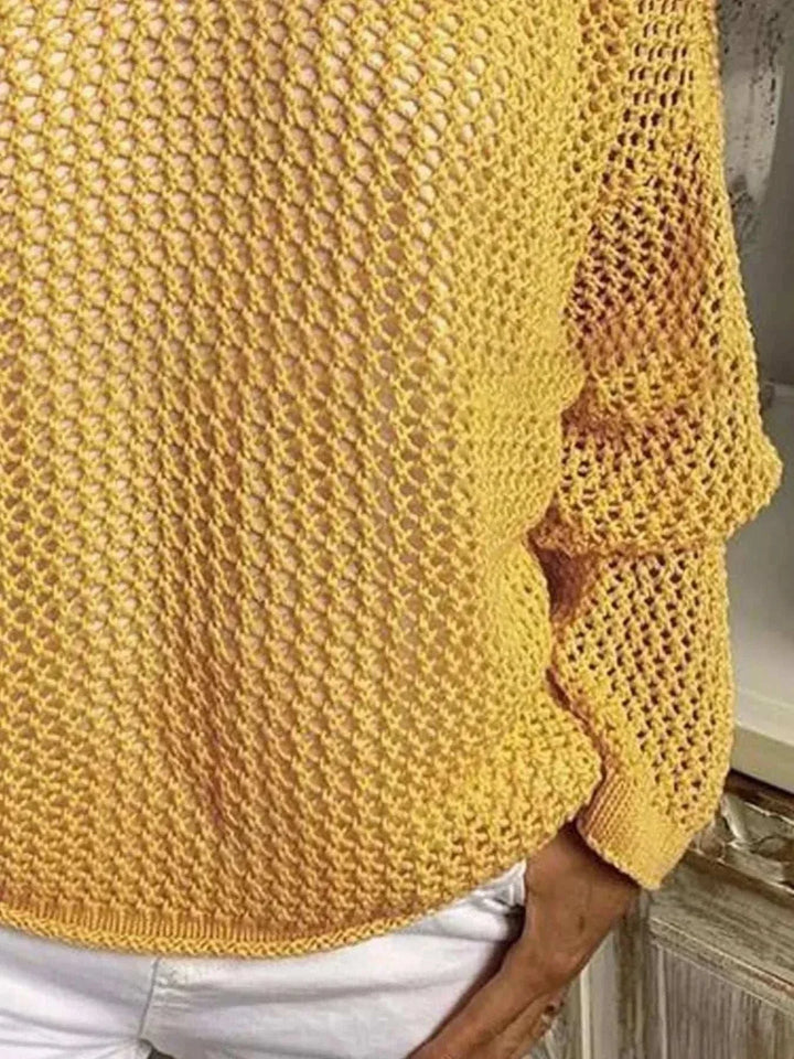 Woman wearing a lightweight openwork knit hooded cover-up by Hot Topic Goods at the beach