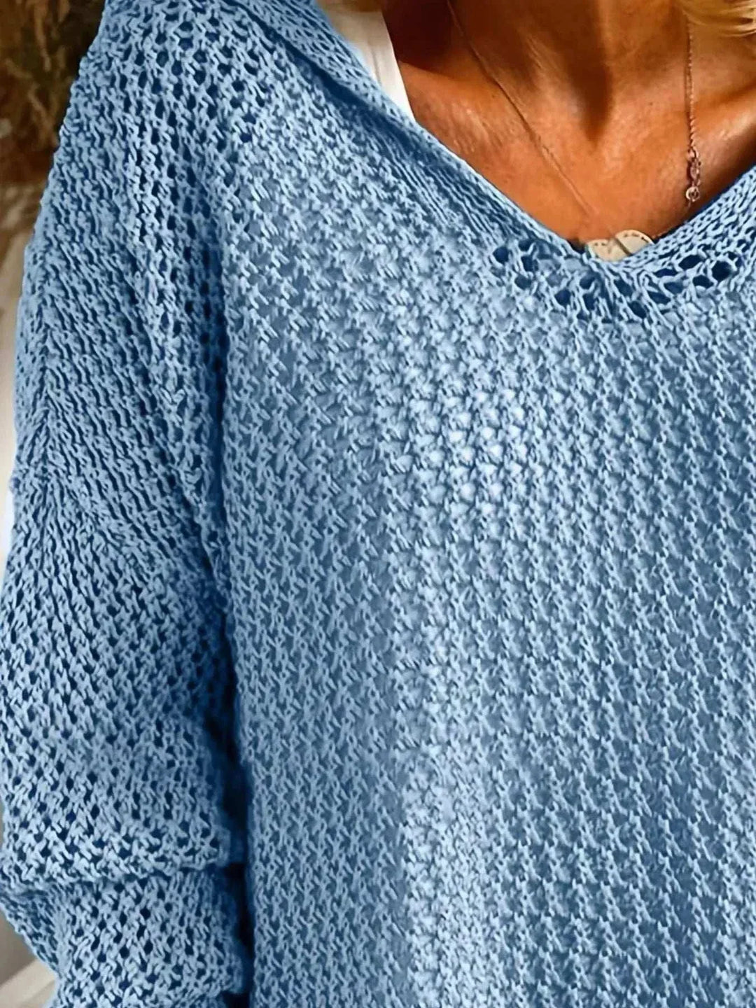 Woman wearing a lightweight women’s hooded knit cover-up with long sleeves and openwork knit design from Hot Topic Goods, styled for beach or casual wear