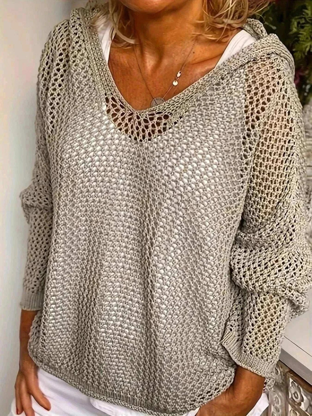 Woman wearing lightweight long sleeve hooded knit cover-up from Hot Topic Goods over swimwear at the beach