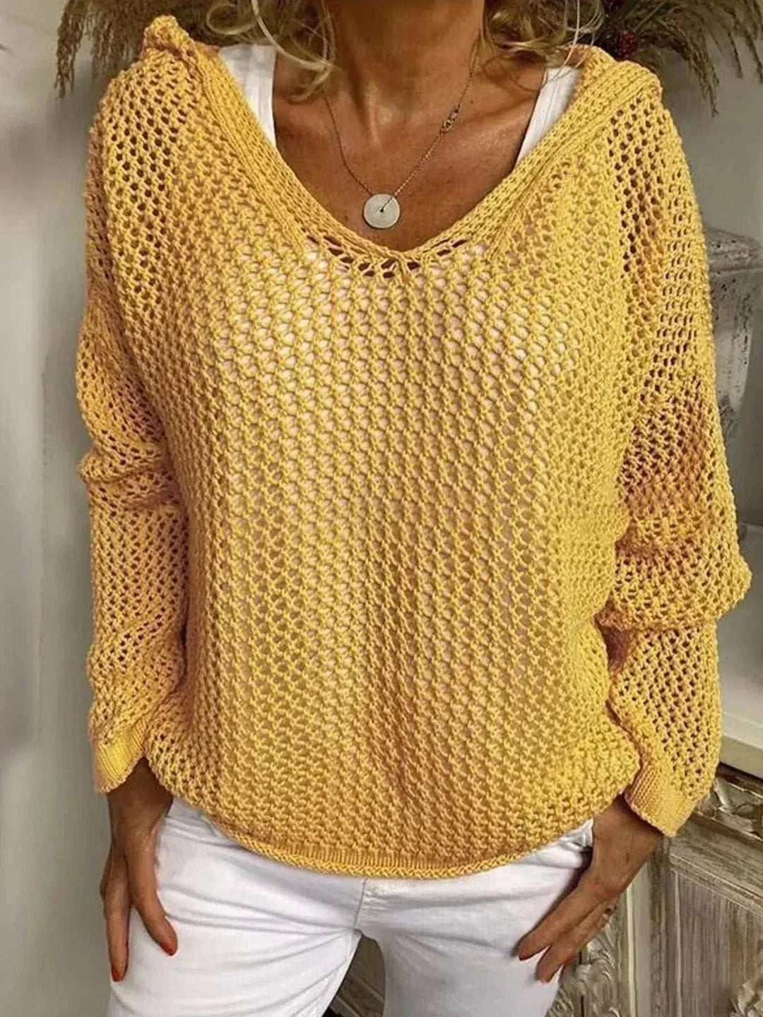 Woman wearing a lightweight openwork knit hooded cover-up from Hot Topic Goods over swimwear at the beach