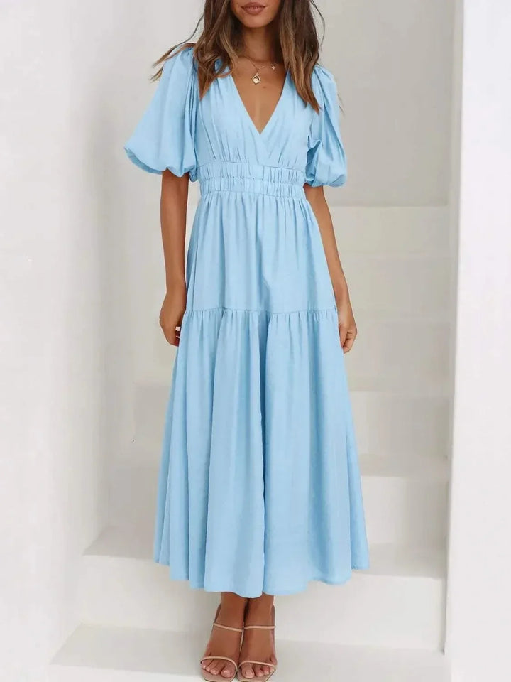 Woman wearing a V-neck puff sleeve midi dress from Hot Topic Goods in a stylish casual setting