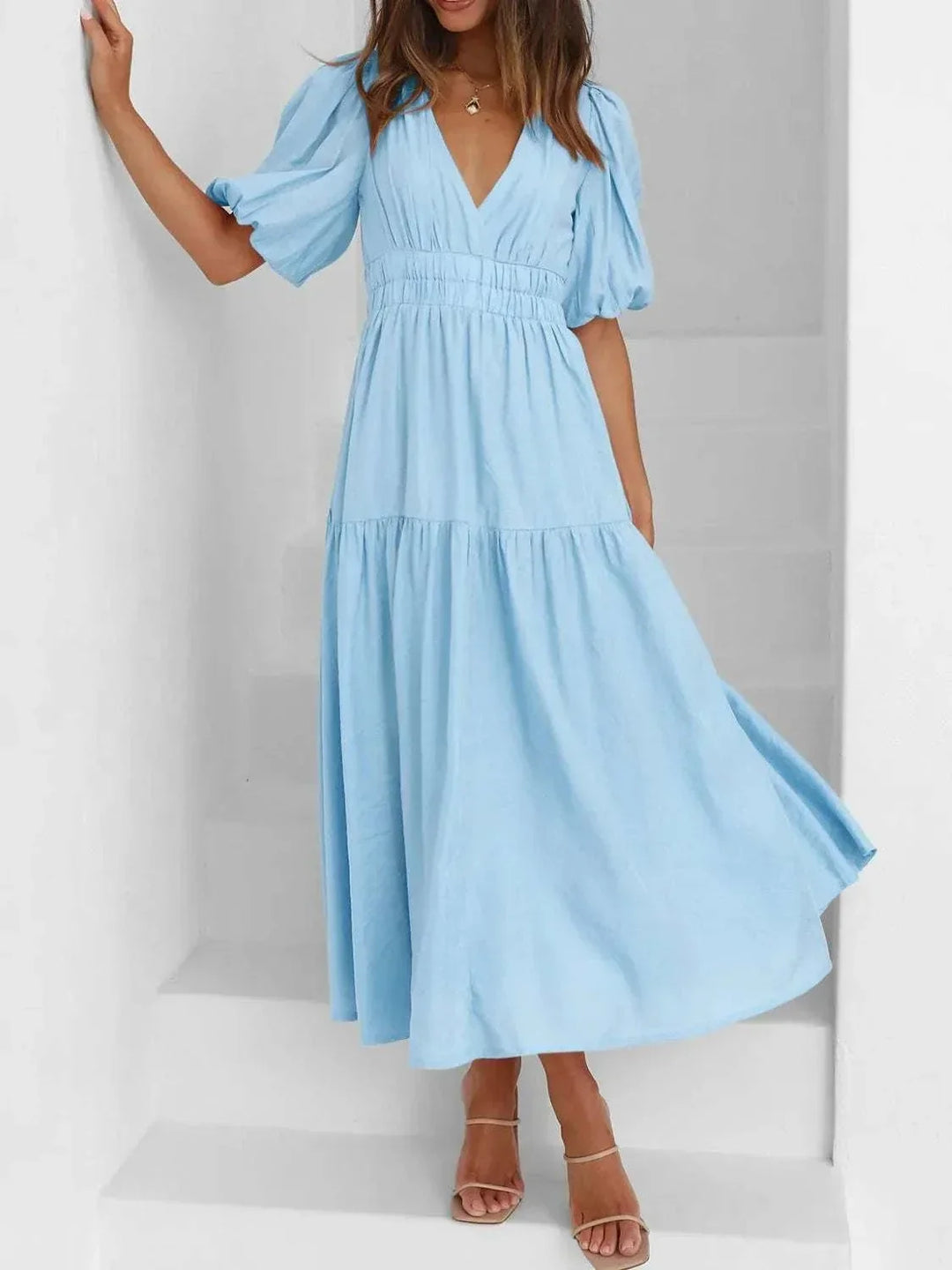 Woman wearing a V-neck puff sleeve midi dress with a flattering silhouette from Hot Topic Goods