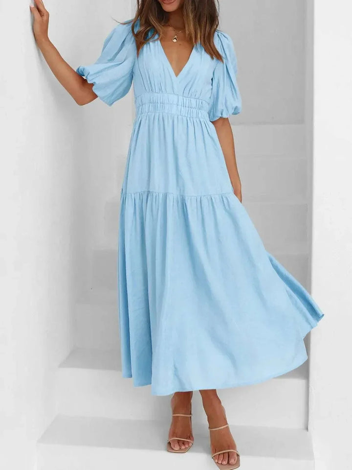 Woman wearing a V-neck puff sleeve midi dress with a flattering silhouette from Hot Topic Goods