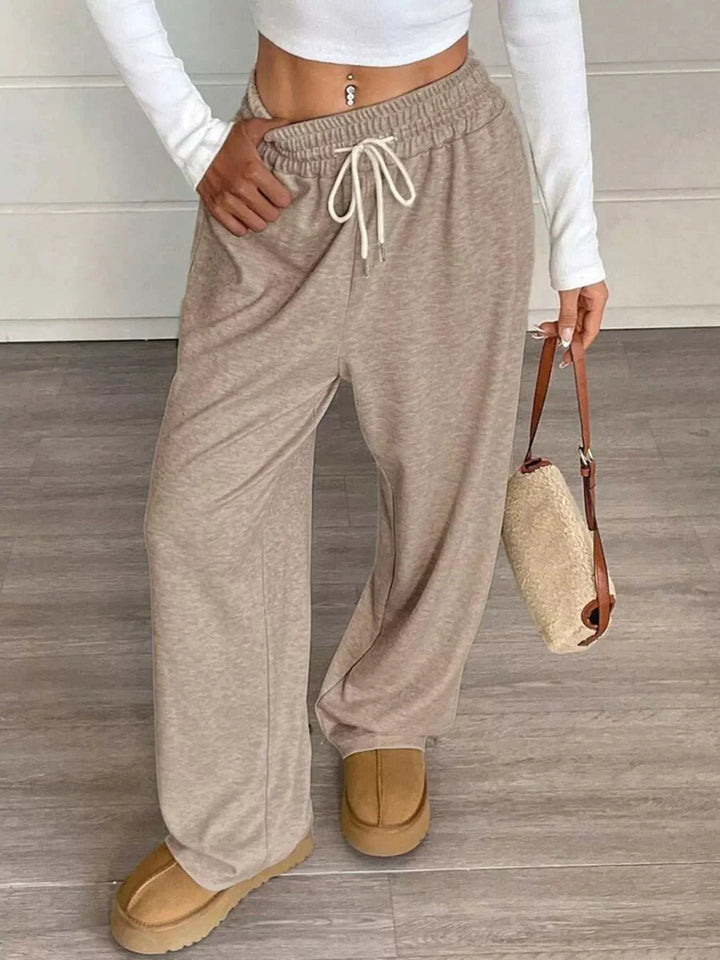 Woman wearing high-waisted wide-leg drawstring pants from Hot Topic Goods in casual outfit
