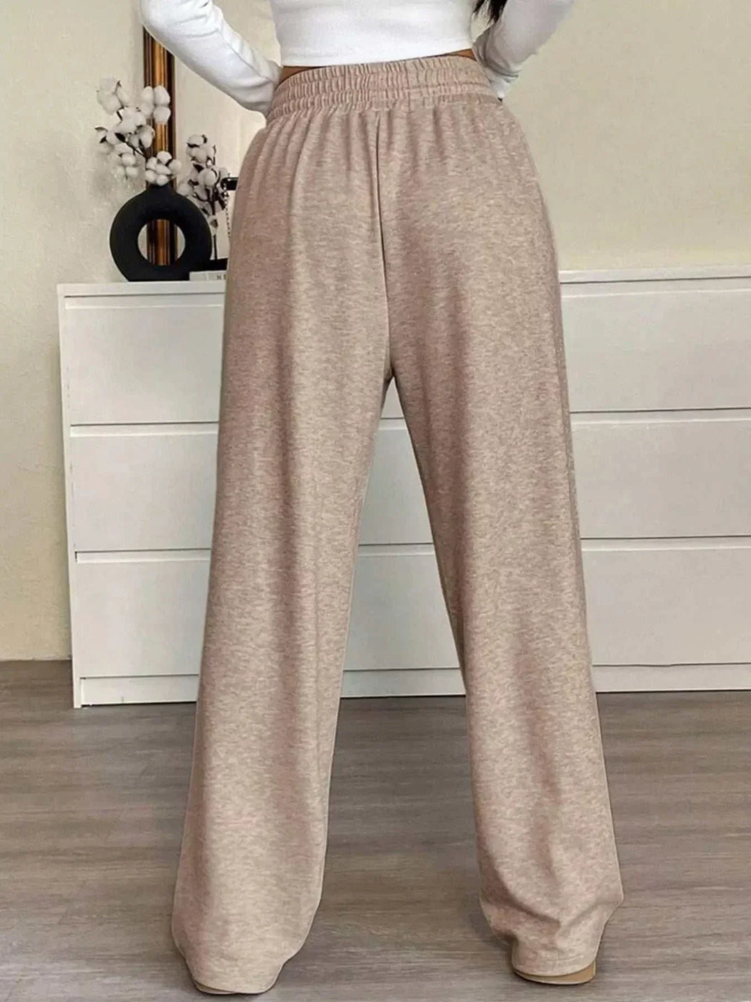 Woman wearing high-waisted wide-leg drawstring pants from Hot Topic Goods