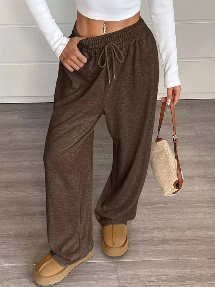 Women wearing high-waisted wide-leg drawstring pants from Hot Topic Goods in casual setting