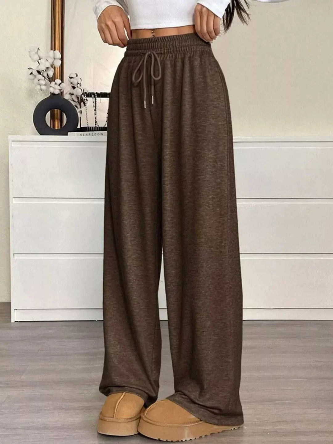 Woman wearing high-waisted wide-leg drawstring pants from Hot Topic Goods in casual setting
