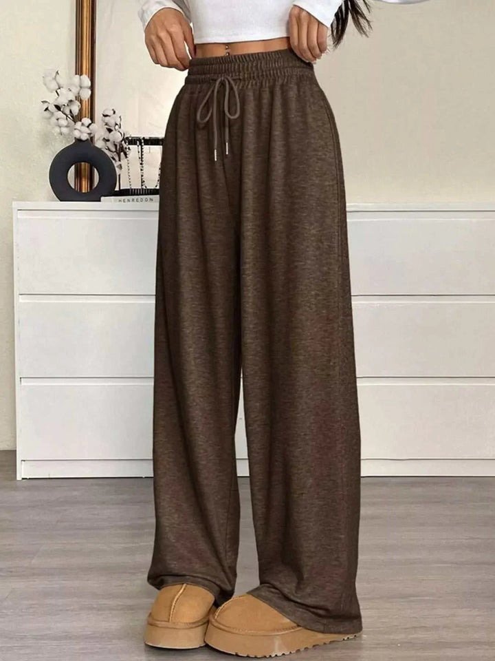 Woman wearing high-waisted wide-leg drawstring pants from Hot Topic Goods in casual setting