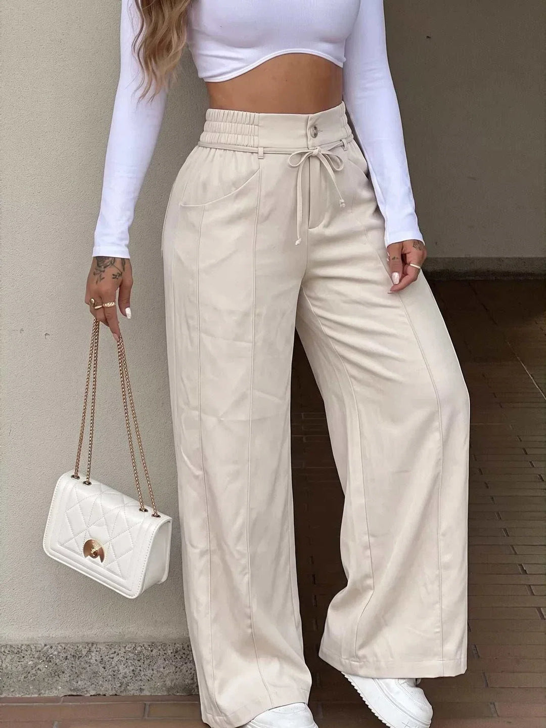 Woman wearing high-waisted wide-leg pants from Hot Topic Goods in casual stylish outfit