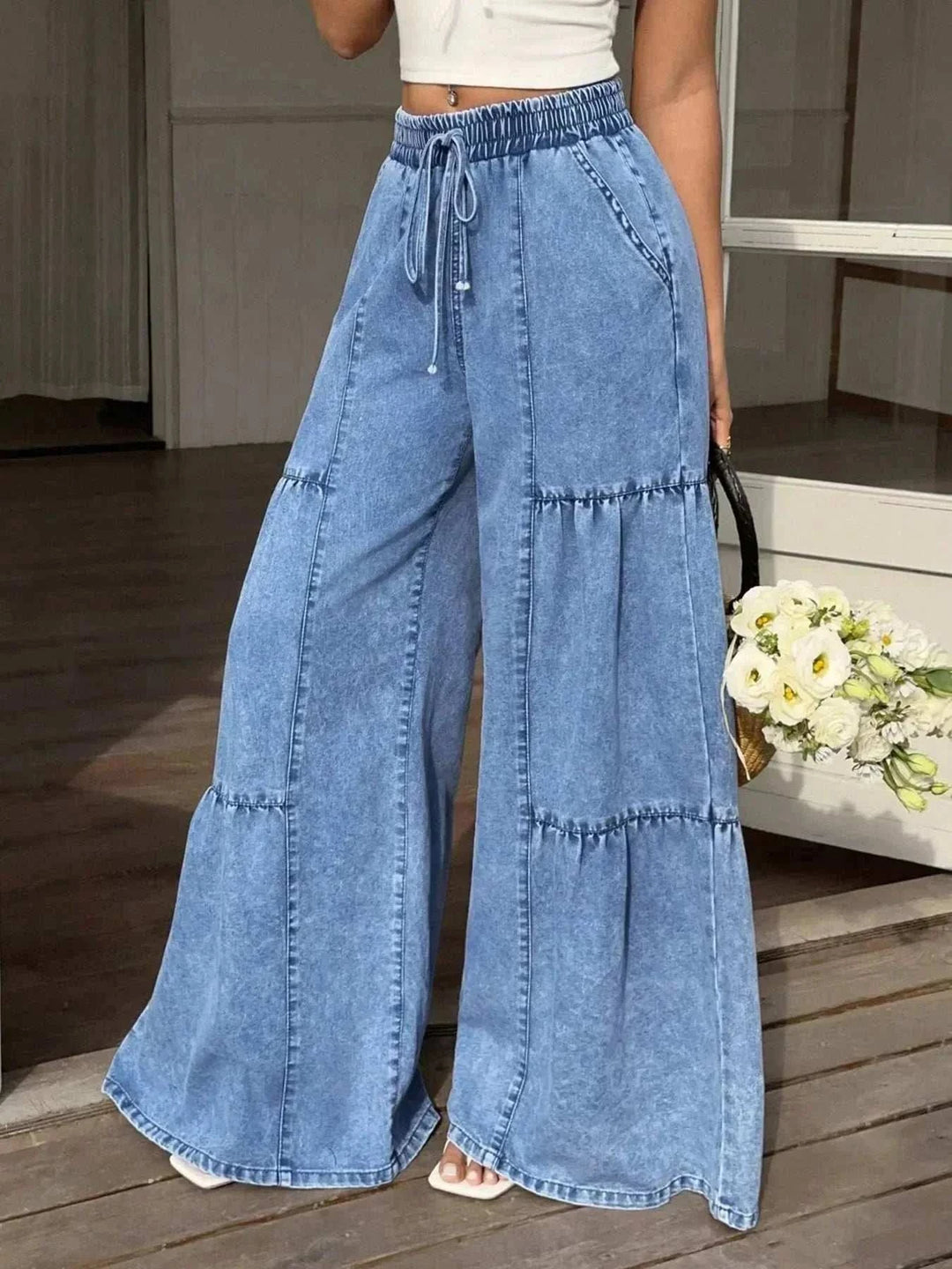 Women's Wide Leg Tiered Jeans in light blue washed denim with an elastic drawstring waist and stitched tier seams