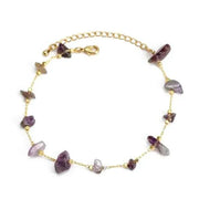 Delicate charm bracelet with purple stones on a gold chain, perfect for personal expression and style.