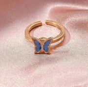 Fidget Spinner Ring with blue butterfly design on pink fabric background.