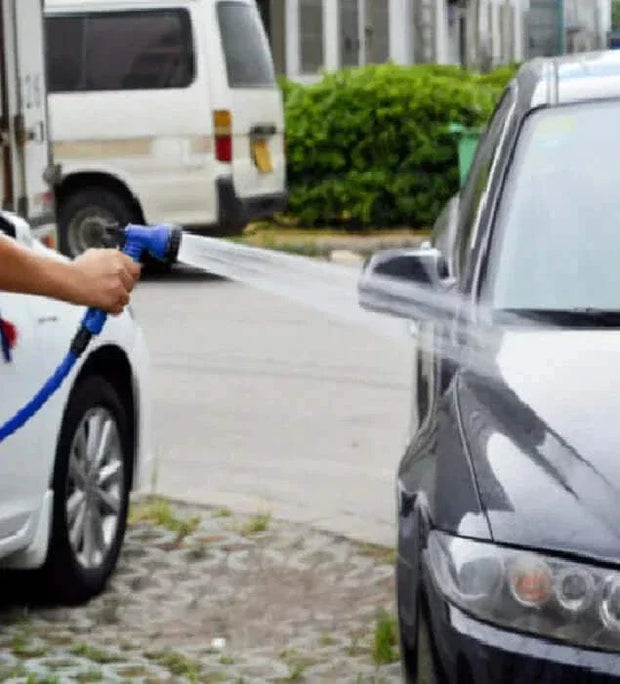 Flexible garden hose in use for washing a car.