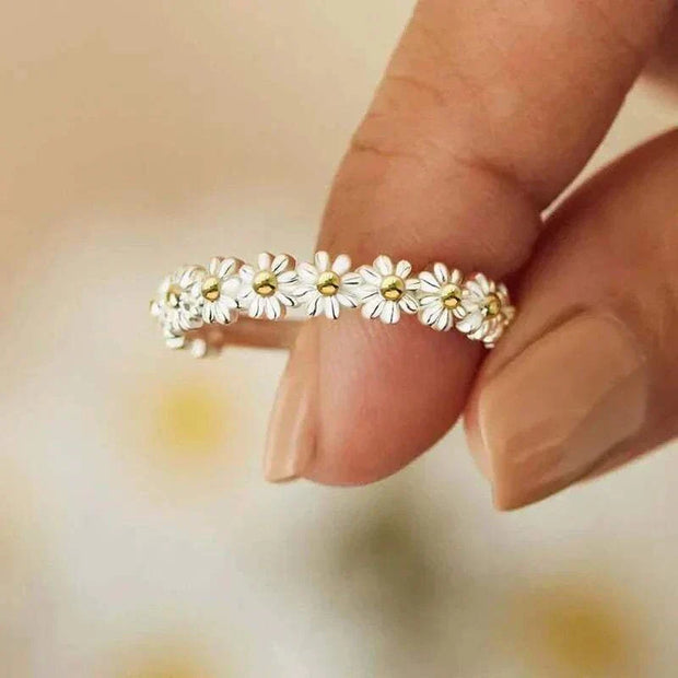 Fidget Spinner Ring with floral design held between fingers, stylish stress-relief accessory.