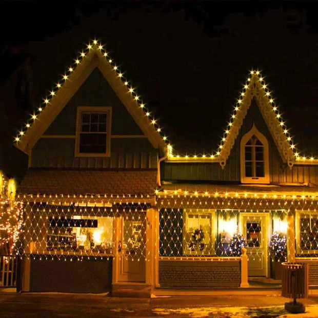 Net Mesh Solar Fairy Lights illuminating a house exterior at night, enhancing festive decor.