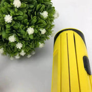 Pet Hair Remover Brush with compact design next to a decorative green plant.