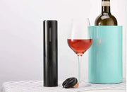 Automatic wine bottle opener with sleek design next to wine bottle and glass.