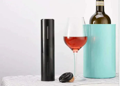 Automatic wine bottle opener with sleek design next to wine bottle and glass.