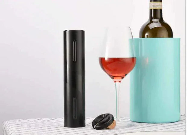 Automatic wine bottle opener with sleek design next to wine bottle and glass.